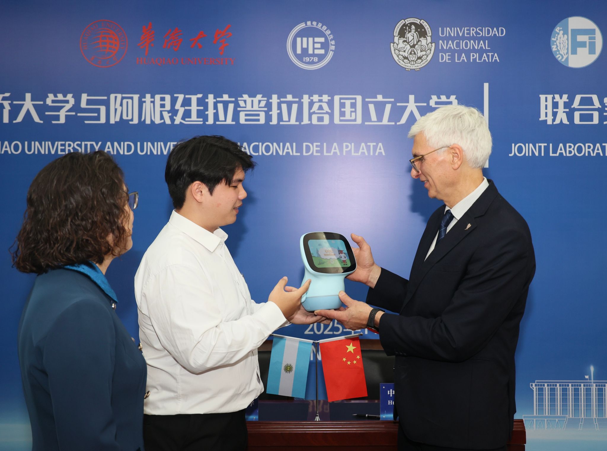 王华珍老师(左一)和杨家迅(左二)向阿根廷拉普拉塔国立大学副校长介绍华文教育机器人.jpg