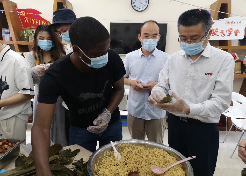 吴建平校长与安哥拉学生卫宇达包粽子.jpg 吴建平校长与安哥拉学生卫宇达包粽子.jpg